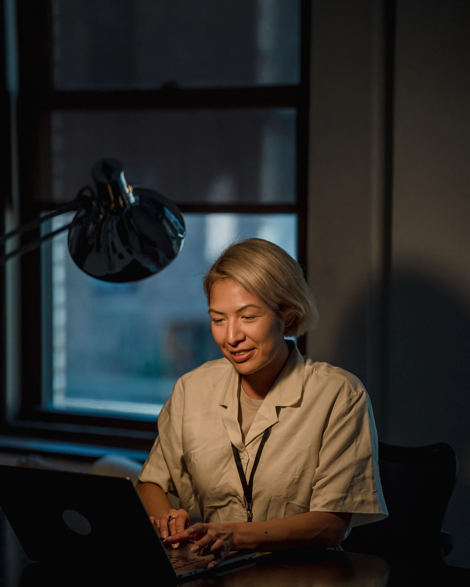 A seller running her store from a laptop in a dim office