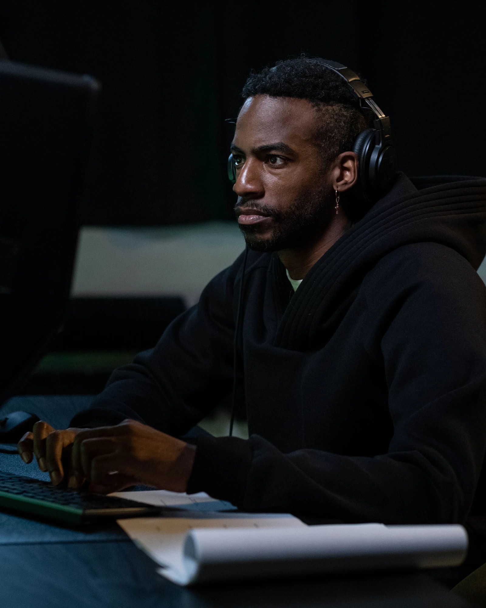 A support specialist in a headset working at a dark desk